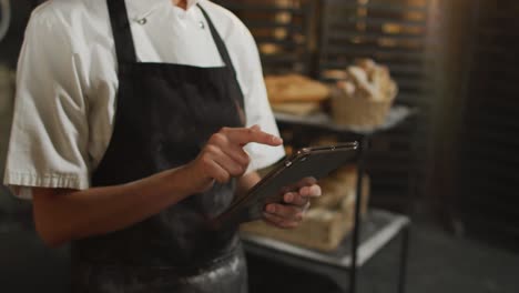 animation of midsection of asian female baker using tablet