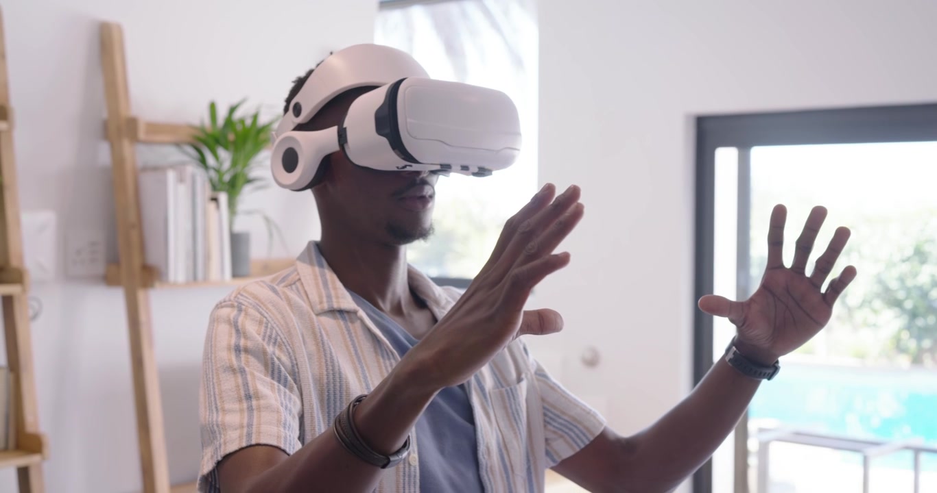 Couple watching man using VR at home after prompt pointing, removing headset, checking controllers