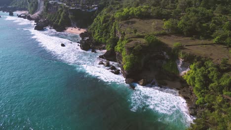 waves of turquoise water sea crashing a cliff in balangan beach, uluwatu, bali - indonesia