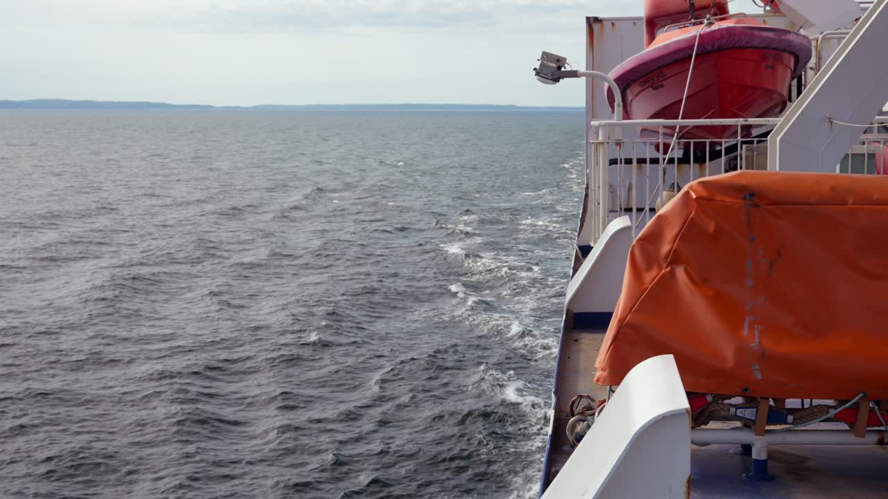 Ferry desplazando agua, vista hacia el horizonte con barco de rescate, Mar Báltico