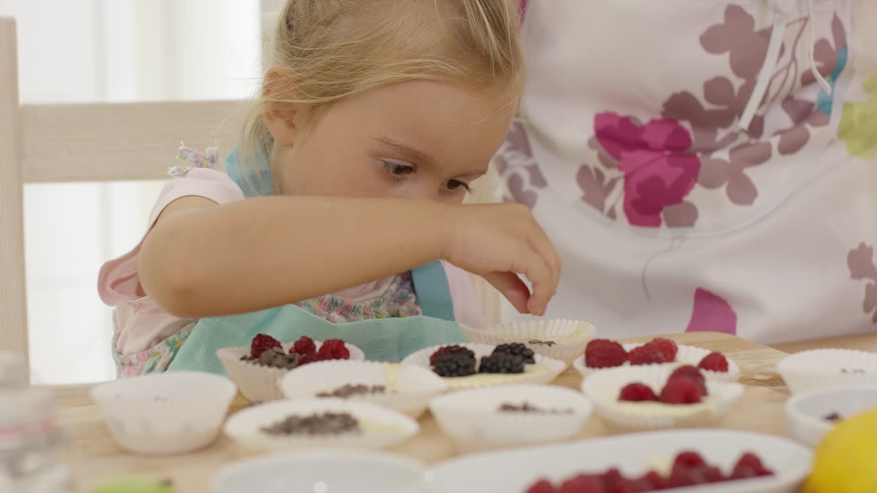 niño y mujer preparando muffins en la mesa