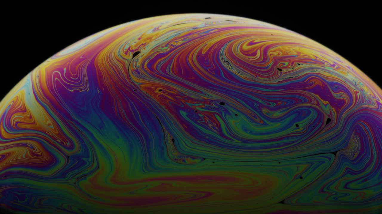 la superficie de la película líquida del jabón con remolinos de colores arco iris: toma macro abstracta