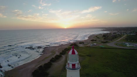 sunset view of farol lighthouse in portugal with ocean waves and coastal landscape, aerial view