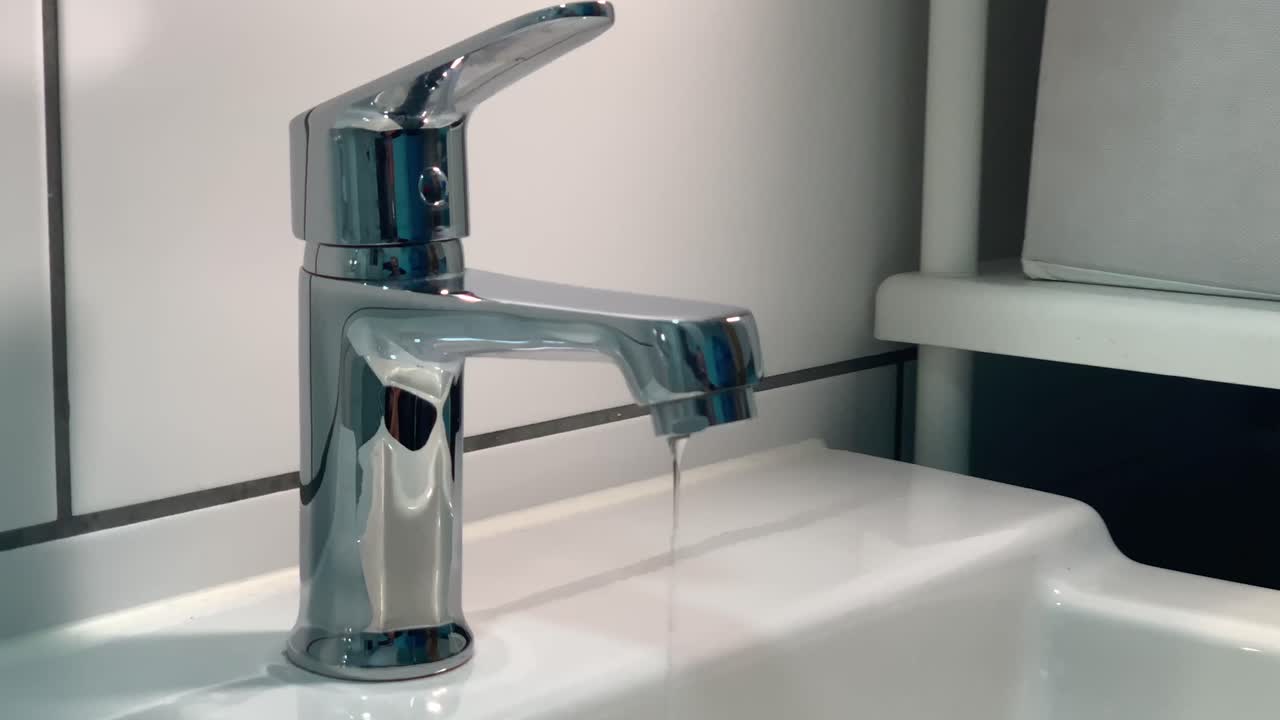 fuga de agua del grifo de metal del baño