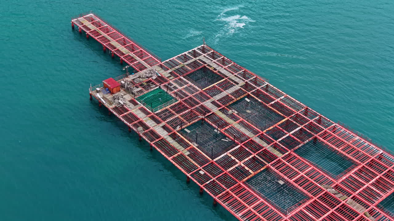 Mussel farm located in the sea with structures for growing shellfish and nets for collection in clear water during sunlight hours
