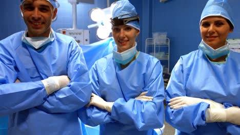 retrato del cirujano y las enfermeras de pie con los brazos cruzados en la sala de operaciones