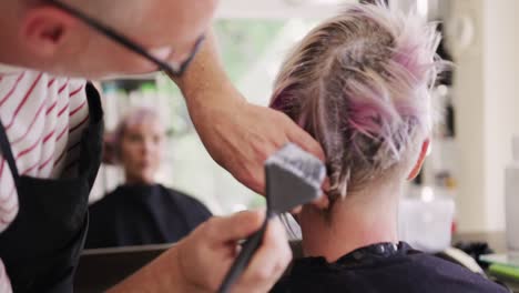 rear view woman having her hair styled by a hairdresser