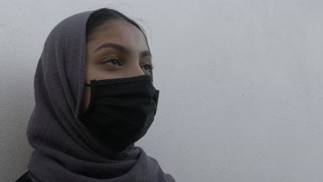Weiblicher-Teenager-Mit-Kopftuch-Und-Gesichtsmaske-Draußen-Vor-Weißer-Wand