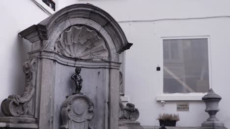 statue of manneke pis in the city center of brussels from a distance