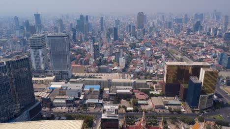 phnom penh city under hazy sky due to toxic air pollution with preah sihanouk boulevard and historical independence monument park on the right, cambodia skylines, drone shot
