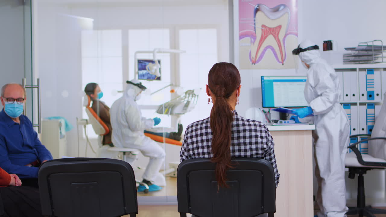 asistente con traje de ppe viene a la recepción