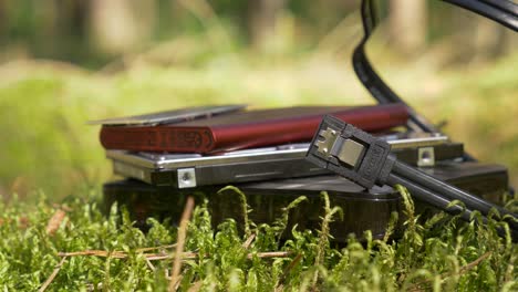 slide shot of external and internal hard drives and ssd on the moss in the forest