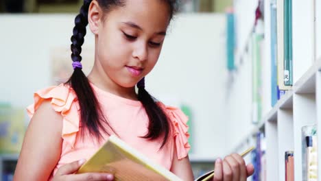 estudiante leyendo un libro en la biblioteca de la escuela