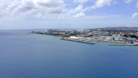 Flight-in-Barbados,-Bridgetown-from-Carlisle-Bay-towards-Bridgetown-Harbour-Cruise-Pier-where-a-cruise-ship-is-docked