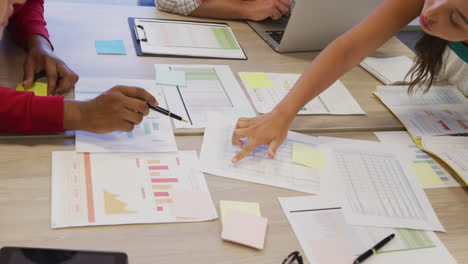 Diverse-male-and-female-business-colleagues-with-documents-at-meeting