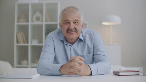 portrait-of-middle-aged-gray-haired-man-talking-to-camera-concept-of-video-chat-or-webinar-blogger-or-teacher