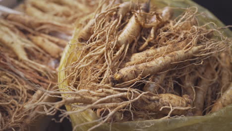 Fresh-bulk-ginseng-root-at-Gwangjang-Market-in-Seoul-Korea,-medium-to-close-up-shot-in-slow-motion