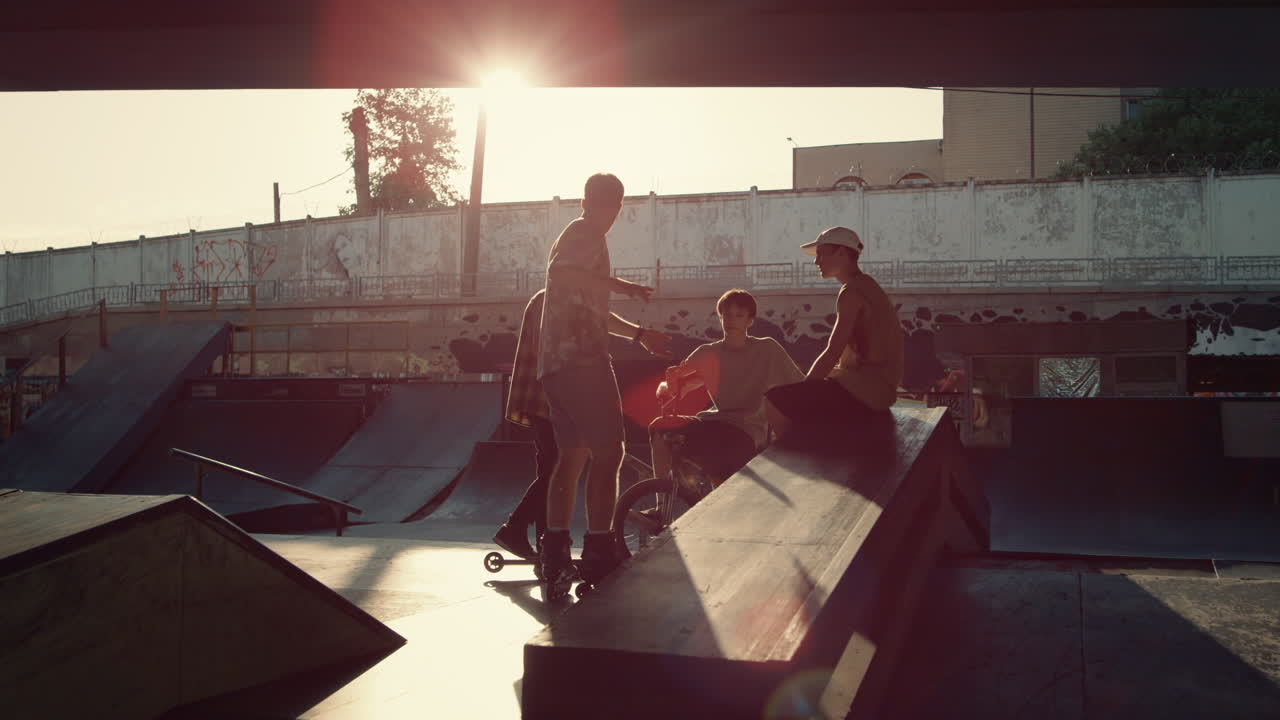 Young guys communicating in skate park. Riders discussing training session.