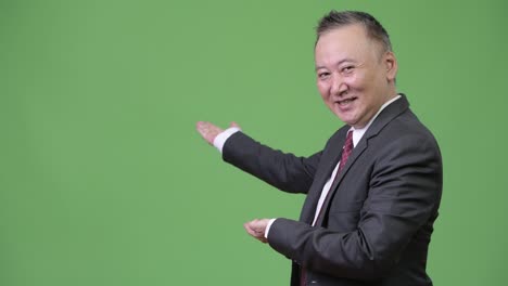 mature japanese businessman showing something