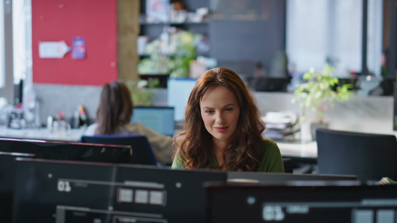 Primo piano di una signora sorridente che lavora al portatile in ufficio. Donna felice che guarda lo schermo del computer
