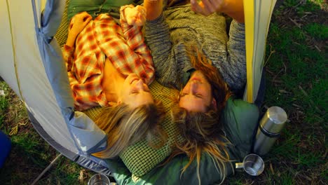 high angle view of young couple discussing over mobile phone in tent 4k