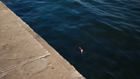 Empty-soda-can-floating-in-the-sea-on-the-coast-of-Split,-Croatia