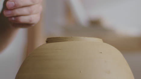 working on a clay vase on a potter's wheel during pottery process