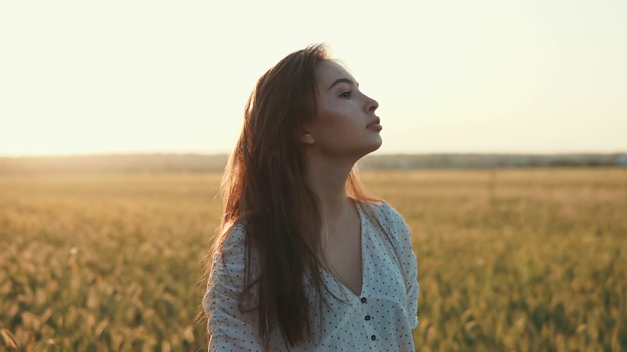 mujer en un campo de trigo al atardecer