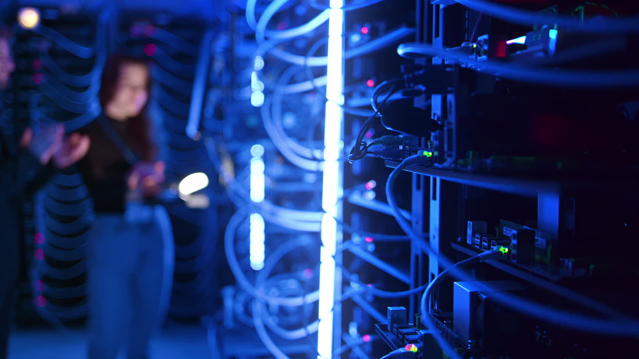 A man and a woman programming in a server room