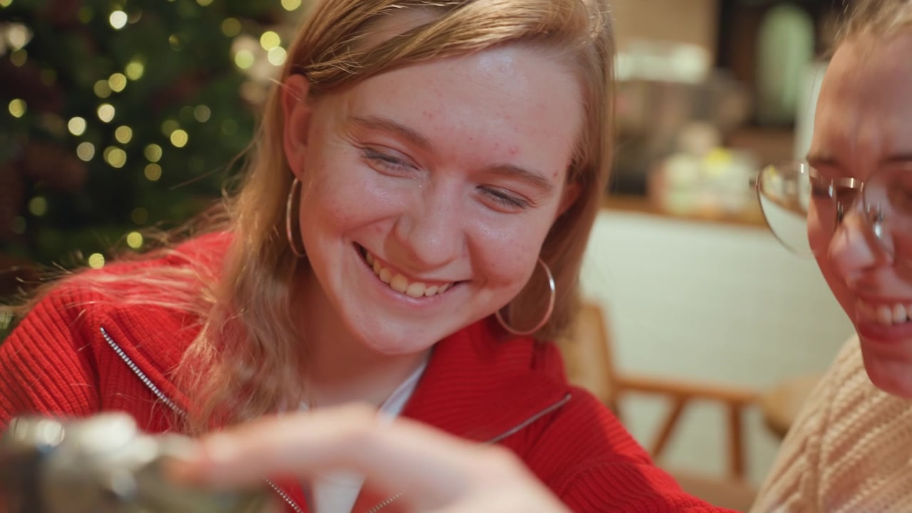 To glade venner kigger ind i et kamera på en festlig café