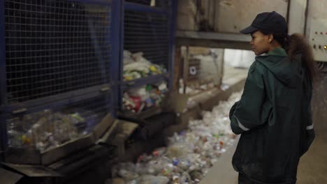 Eine-Junge-Afroamerikanerin-überprüft-Ein-Förderband-In-Einer-Recyclinganlage.-Umweltschutz