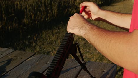 limpiar un rifle, para limpiar un cañón de arma en un campo de tiro soleado, práctica al aire libre