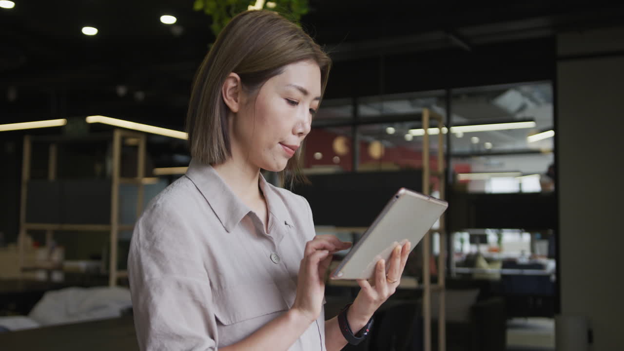 현대 사무실 에서 디지털 태블릿 을 사용 하고 있는 아시아 사업가
