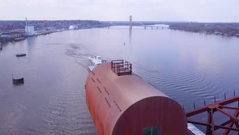 a beautiful aerial of a barge traveling under a steel drawbridge on the mississippi river