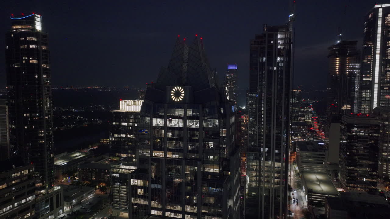 Nighttime cityscape featuring illuminated skyscrapers and the Frost Bank Tower