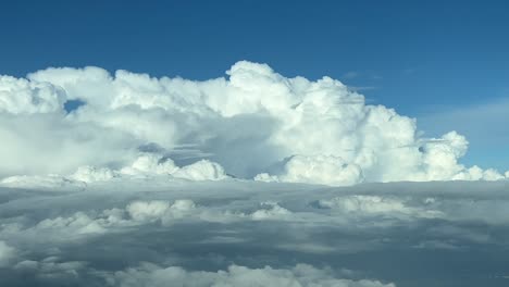 aerial view taken from a jet cockpit of some huge cumulonimbus during daylight