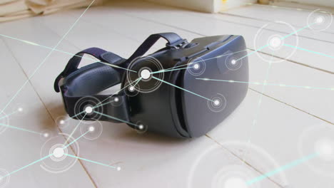 Animation-of-communication-network-over-vr-headset-lying-on-wooden-floor