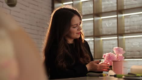 A Woman Delicately Arranges Beautiful Pink Flowers in a Pot Savoring a Serene Moment of Pure a Woman Delicately Arranges Beautiful Pink Flowers in a Pot Savoring a Serene Moment of Pure Creativity