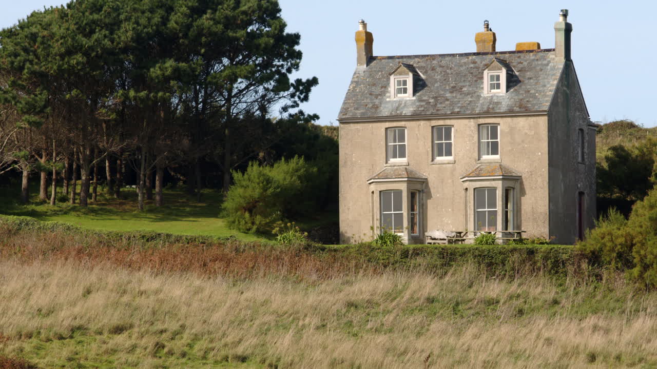 Longshot of a three story Georgian house at Bessy's Cove, The Enys