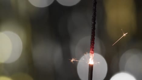 video of close up of sparkler with bokeh and copy space on black background