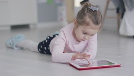 Chica-Relajante-Jugando-Tablet-En-El-Piso