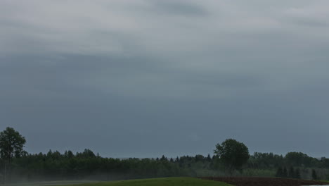 Timelapse-De-Nubes-Oscuras-Sobre-Un-Bosque-Y-Un-Campo