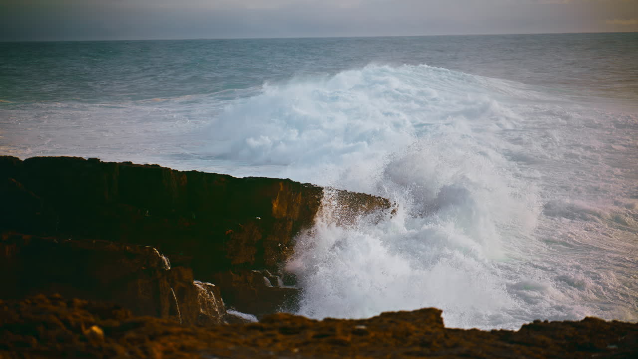 las olas costeras golpean las piedras en un día tormentoso. poderoso océano rodando golpeando la playa