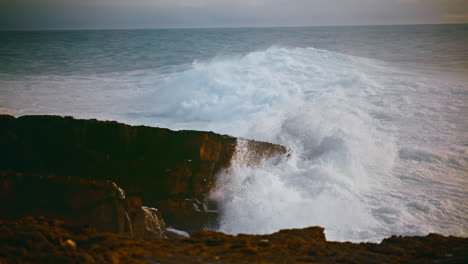 coastal waves hitting stones on stormy day. powerful ocean rolling hitting beach