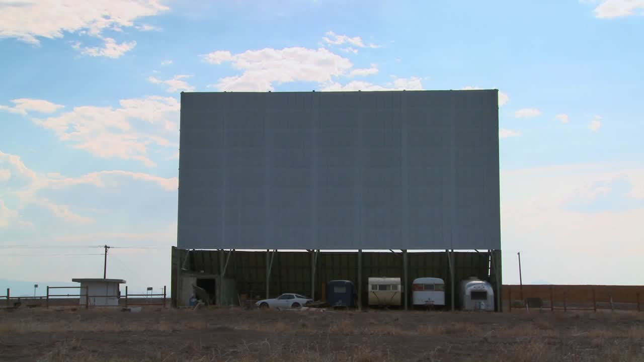 una toma de nubes pasando sobre un camino abandonado en la pantalla de cine 1