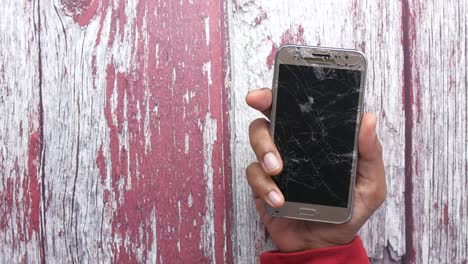 broken smartphone on wooden background