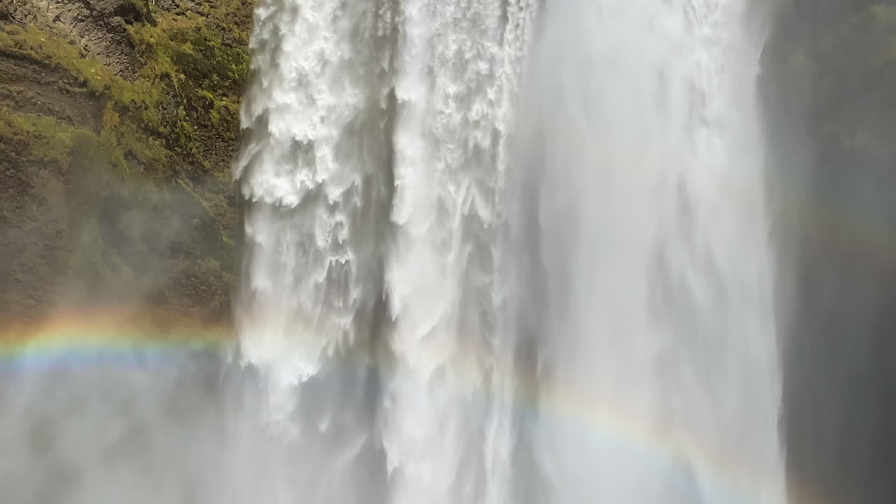 skogafoss closeup inclinado hacia abajo en la famosa cascada islandesa con arco iris