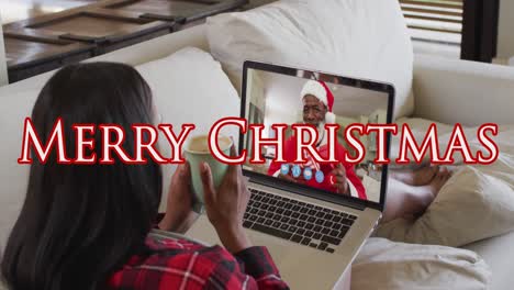 Animation-of-merry-christmas-text-over-caucasian-woman-on-laptop-video-call-with-her-family