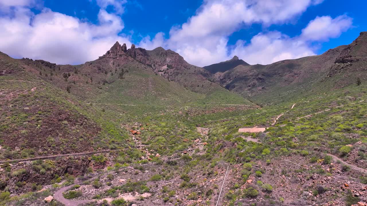 Lush volcanic slopes in Adeje with rugged mountain ridges and scenic hiking paths
