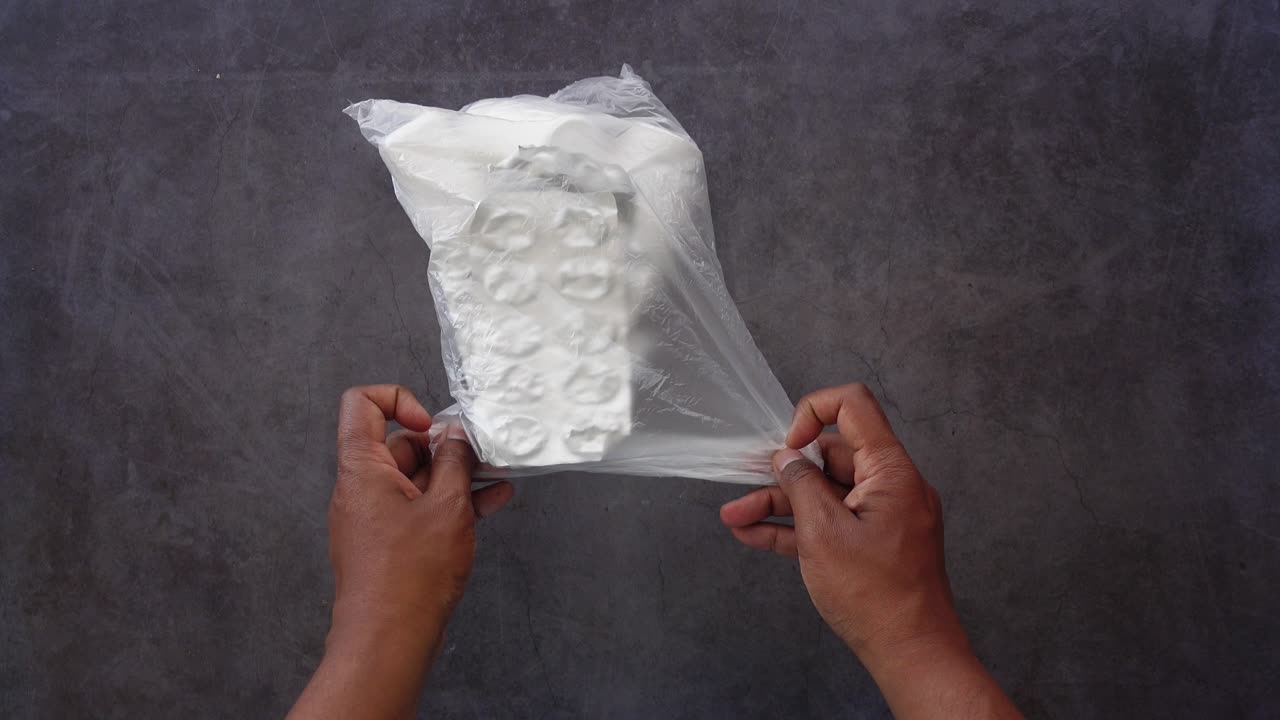 의약품 을 담은 플라스틱 가방 을 들고 있는 손 들